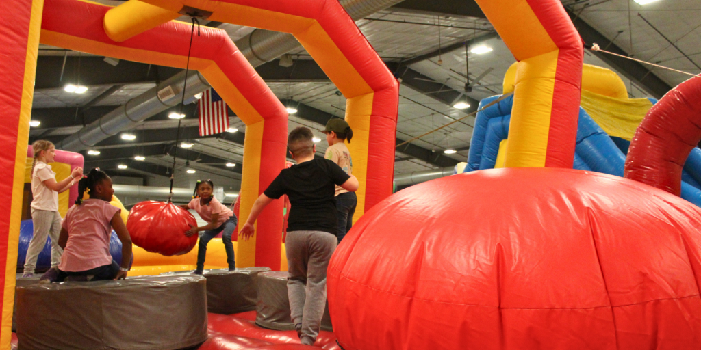 Kids bouncing and playing in the one of the extreme inflatables inside the Event Center at Archer during WYO Bounce Bash. The event featured over 30 inflatables and activities.
